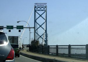 The Ambassador Bridge span between Detroit and Windsor photographed from the roadway, with vehicles queued in the right lane