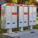 A Canada Post community mailbox unit standing on a grass verge in a residential street