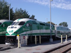 A green and white GO Transit train stopped on the Barrie line.