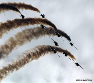 Nine Canadian Forces Snowbirds jets in formation trailing smoke against cloud during the Canadian International Air Show over Toronto.