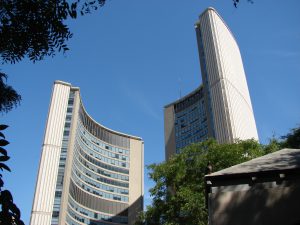 The curved towers of Toronto City Hall seen across Nathan Phillips Square.