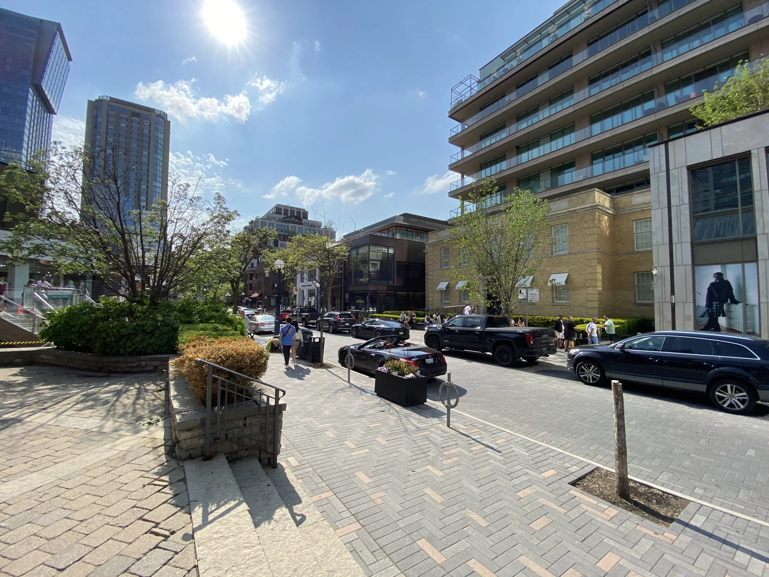 Shops and low-rise buildings lining Yorkville Avenue in Toronto on a clear day.